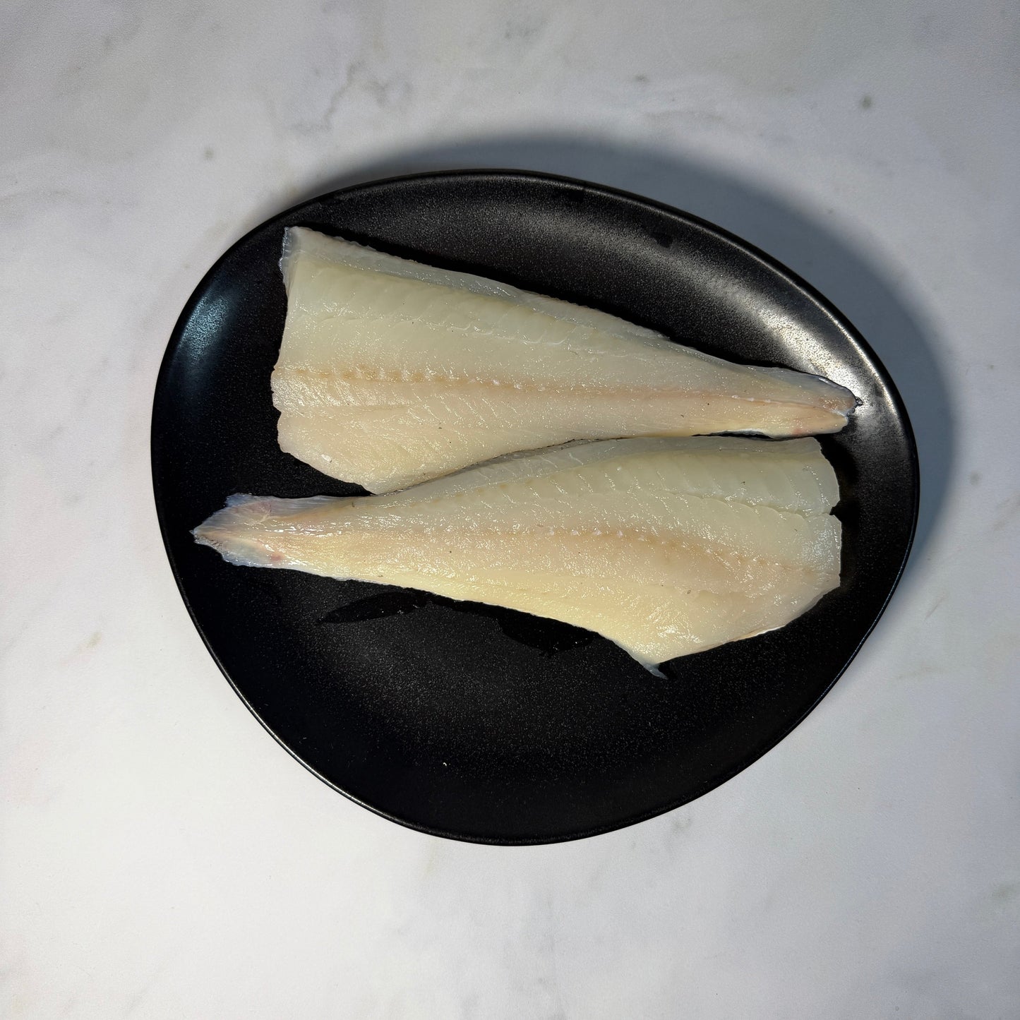 Fresh Wild Haddock Fillets on a slate background, from Hamiltons Fish