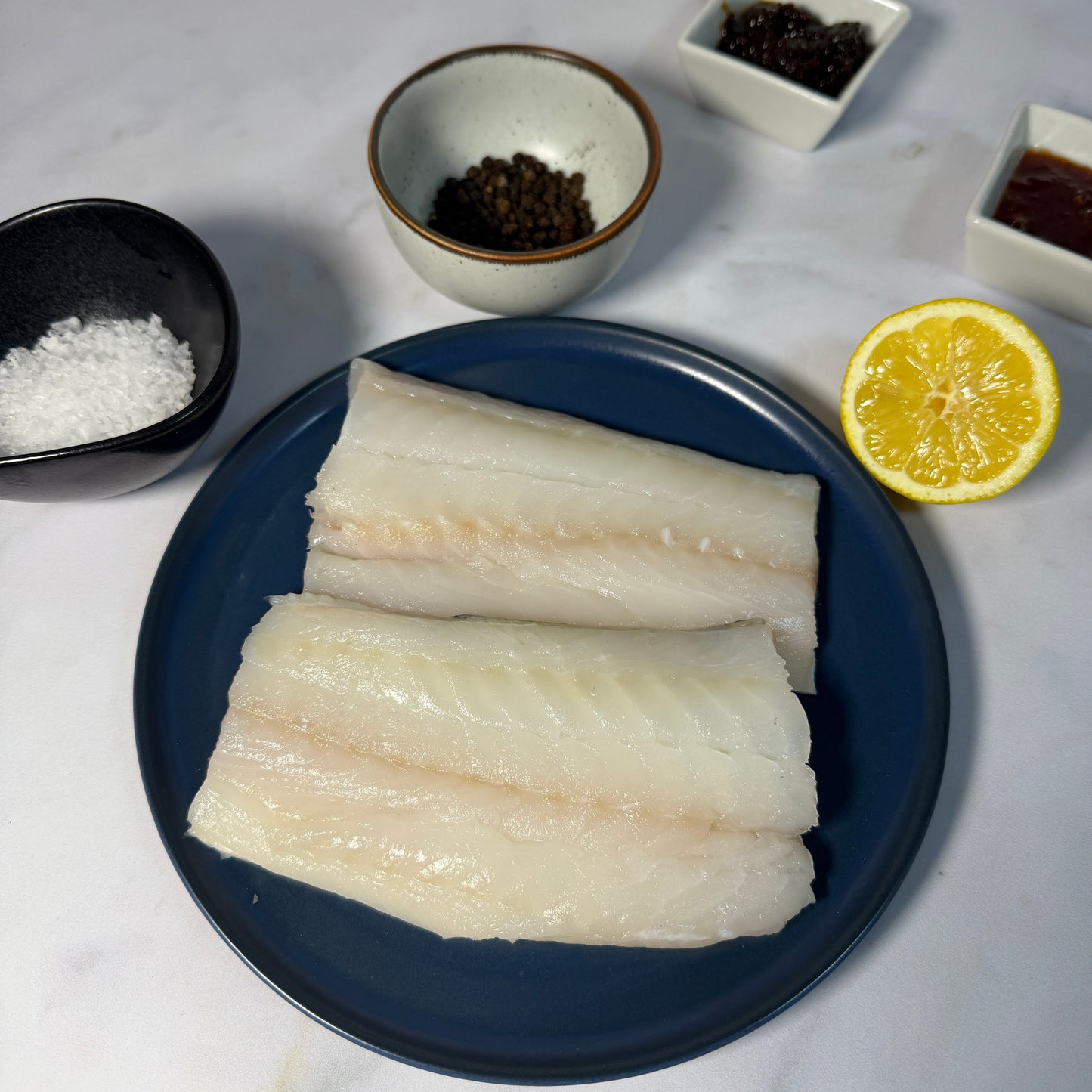 Fresh Wild Cod Fillets on a slate background, from Hamiltons Fish